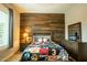 A bedroom with baseball themed decor, wood accent wall and comfortable furnishings at 19777 E Ivy Ln, Queen Creek, AZ 85142