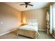Comfortable bedroom with paneled walls, and a white framed bed, side table, and cabinet near the bright window at 19777 E Ivy Ln, Queen Creek, AZ 85142