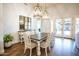 Elegant dining room featuring a wooden table, decorative lighting, and French doors to a covered patio at 19777 E Ivy Ln, Queen Creek, AZ 85142