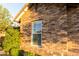 Close-up of a brick exterior showing a window and well-kept greenery with the house number at 19777 E Ivy Ln, Queen Creek, AZ 85142