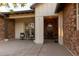 Covered parking with brick and white siding, alongside a front door and sitting area at 19777 E Ivy Ln, Queen Creek, AZ 85142
