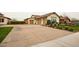 Charming home showcasing a well-manicured front yard, three-car garage, and tasteful landscaping at 19777 E Ivy Ln, Queen Creek, AZ 85142