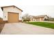 Exterior shot of multi-car garage and charming home with well-maintained lawn and landscaping at 19777 E Ivy Ln, Queen Creek, AZ 85142