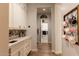 Hallway featuring custom white cabinets, a quartz countertop, and a view of the laundry room at 19777 E Ivy Ln, Queen Creek, AZ 85142