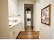 Hallway with hardwood floors, white cabinets, and a view of the laundry room creates an inviting, organized transition at 19777 E Ivy Ln, Queen Creek, AZ 85142