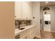 Hallway with custom cabinets, mosaic backsplash, and wood floors, leading into the laundry room at 19777 E Ivy Ln, Queen Creek, AZ 85142