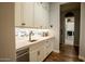 This hallway features white cabinets and drawers, quartz countertop, and wood floors, leading to the laundry room at 19777 E Ivy Ln, Queen Creek, AZ 85142