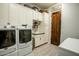 Laundry room features modern washer and dryer, sink, counter and custom cabinets at 19777 E Ivy Ln, Queen Creek, AZ 85142