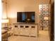 Comfortable living room with neutral walls, an entertainment cabinet and a closet with storage bins at 19777 E Ivy Ln, Queen Creek, AZ 85142