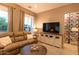 Inviting living room with a comfortable couch, entertainment center, and ample natural light at 19777 E Ivy Ln, Queen Creek, AZ 85142