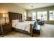 A spacious main bedroom with a king-size bed, seating area, and views of the pool at 19777 E Ivy Ln, Queen Creek, AZ 85142