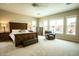 Spacious main bedroom featuring neutral tones, ceiling fan, and an adjacent sitting area at 19777 E Ivy Ln, Queen Creek, AZ 85142