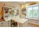 Bright office with custom built-ins, desk, shelving, and large window with bench at 19777 E Ivy Ln, Queen Creek, AZ 85142