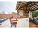 Outdoor bar area with a built-in grill, counter seating, and views of the pool and backyard amenities at 19777 E Ivy Ln, Queen Creek, AZ 85142