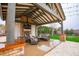 Outdoor living area with a covered patio, fireplace, outdoor kitchen, and comfortable seating for entertaining guests at 19777 E Ivy Ln, Queen Creek, AZ 85142