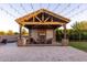 Outdoor pavilion with fireplace, kitchen, seating area, and travertine floors for ultimate comfort and outdoor entertaining at 19777 E Ivy Ln, Queen Creek, AZ 85142