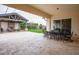 Expansive covered outdoor patio featuring travertine tile, dining and lounge areas, perfect for entertaining at 19777 E Ivy Ln, Queen Creek, AZ 85142