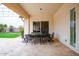 Covered outdoor patio featuring stone flooring and elegant dining set at 19777 E Ivy Ln, Queen Creek, AZ 85142