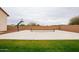 A backyard basketball court with a net, hoop, and neutral-colored privacy wall surrounded by grass at 19777 E Ivy Ln, Queen Creek, AZ 85142