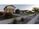 Street view showing the exteriors of homes with landscaping, detached garages and gray driveways at 19777 E Ivy Ln, Queen Creek, AZ 85142