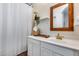 Cozy bathroom features a wood-framed mirror, white vanity, and shower with curtain at 2402 E 5Th St # 1742, Tempe, AZ 85288