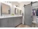 Modern bathroom with double vanity, decorative mirrors, and a sliding barn door to the closet at 24307 S Starcrest Dr, Sun Lakes, AZ 85248