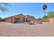 Spacious backyard featuring gravel, a small patch of grass, and patio seating under a covered porch at 2486 E Espada Trl, Casa Grande, AZ 85194