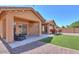 A cozy covered patio and bar seating complement the backyard with gravel and small patch of grass at 2486 E Espada Trl, Casa Grande, AZ 85194
