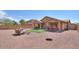 Large backyard with a gravel area, small grass patch, covered patio, and outdoor bar seating at 2486 E Espada Trl, Casa Grande, AZ 85194