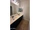 Bathroom featuring double sinks, dark cabinetry and a large mirror to reflect light at 2486 E Espada Trl, Casa Grande, AZ 85194