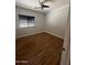 Cozy bedroom with hardwood floors, large window, and ceiling fan at 2486 E Espada Trl, Casa Grande, AZ 85194