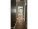 Hallway with tile flooring leading to bedroom with wood flooring and window with blinds at 2486 E Espada Trl, Casa Grande, AZ 85194