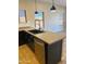 A modern kitchen island with sink, stainless steel dishwasher, and pendant lights at 2486 E Espada Trl, Casa Grande, AZ 85194