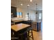 Modern kitchen with black cabinetry, stainless steel appliances, and breakfast bar at 2486 E Espada Trl, Casa Grande, AZ 85194