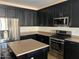 Well-equipped kitchen with dark cabinetry, stainless appliances, and stylish island at 2486 E Espada Trl, Casa Grande, AZ 85194