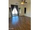 Bright living room featuring dark blinds, hardwood floors, ceiling fan and a sliding glass door at 2486 E Espada Trl, Casa Grande, AZ 85194