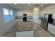 Bright kitchen with stainless steel appliances, granite countertops, large central island and tile floors at 25330 W Bowker St, Buckeye, AZ 85326