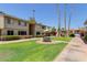 Inviting apartment community featuring lush landscaping, a table with an umbrella, and well-maintained walkways at 2605 W Rose Ln # B101, Phoenix, AZ 85017