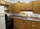 Traditional kitchen featuring wood cabinets, laminate countertops, and black appliances at 2605 W Rose Ln # B101, Phoenix, AZ 85017