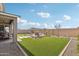 Lush backyard featuring a covered patio, seating area with a fire pit, and pristine landscaping at 26388 N 77Th Dr, Peoria, AZ 85383