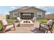 Inviting backyard with a paved patio, seating area with a fire pit, and lush green lawn at 26388 N 77Th Dr, Peoria, AZ 85383
