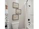 Bathroom showcasing white tiled walls, toilet, and shower/tub combination with modern fixtures and stylish wall art at 26388 N 77Th Dr, Peoria, AZ 85383