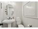 Elegant powder room with a round mirror, modern fixtures, and chic tilework for a sophisticated look at 26388 N 77Th Dr, Peoria, AZ 85383