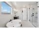 Luxurious bathroom featuring a freestanding tub, glass shower, and modern vanity with natural light at 26388 N 77Th Dr, Peoria, AZ 85383