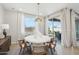 Bright dining room with a modern round table, statement lighting, and sliding glass doors to the outdoor area at 26388 N 77Th Dr, Peoria, AZ 85383