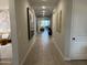 Long hallway with modern, minimalist artwork, wood floors, and white doors, leading into a naturally lit living area at 26388 N 77Th Dr, Peoria, AZ 85383