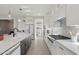 Well-lit kitchen featuring a large island with sink, modern appliances, and stylish cabinetry for ample storage at 26388 N 77Th Dr, Peoria, AZ 85383