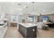 Open-concept kitchen featuring an island with seating, modern appliances, and seamless flow into the dining and living areas at 26388 N 77Th Dr, Peoria, AZ 85383