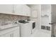 Well-organized laundry room with modern washer and dryer, sink, and ample cabinet space for convenience and style at 26388 N 77Th Dr, Peoria, AZ 85383