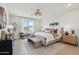Bright main bedroom featuring a large window, stylish decor, and a comfortable sitting area for relaxation at 26388 N 77Th Dr, Peoria, AZ 85383